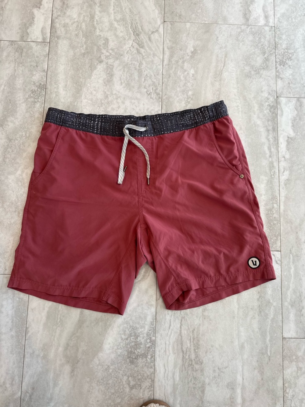 Vuori Men's Swim Hybrids in Burgundy with Black Waistband elastic is flawed.